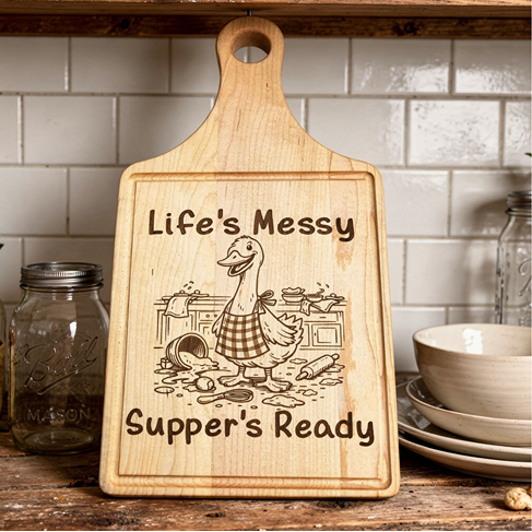 Wooden cutting board with engraved text and design on a kitchen shelf.